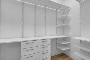 Ein weißer Schrank mit mehreren Regalen und Schubladen.