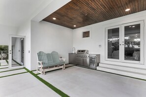 A modern kitchen with a built-in oven and microwave, a wooden ceiling, and a view through large windows. - New Luxury Key Colony Beach 5BR | Pool + 40' Dock (Key Colony Beach)