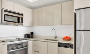 Eine moderne Küche mit Edelstahlgeräten, einem Geschirrspüler und einer Kaffeemaschine.