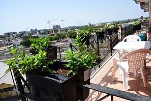 A balcony with potted plants, a white table, and a chair. - In a quiet neighborhood not far from downtown and very close to the subway and bus stops (Bari)