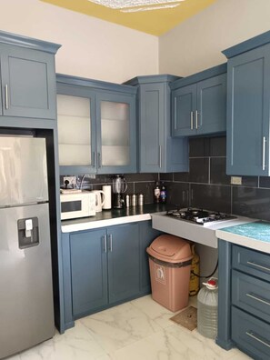 A kitchen with blue cabinets, a stainless steel refrigerator, a microwave, and a gas stove. - Stylish & Spacious Getaway — Comfort, Convenience & A Home Away From Home (Fairy Hill)
