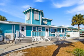 A two-story building with a blue exterior, a small tower-like structure, and a sign indicating it is a beach house. - Gulf Highlands with a Golf Cart! (Panama City Beach)