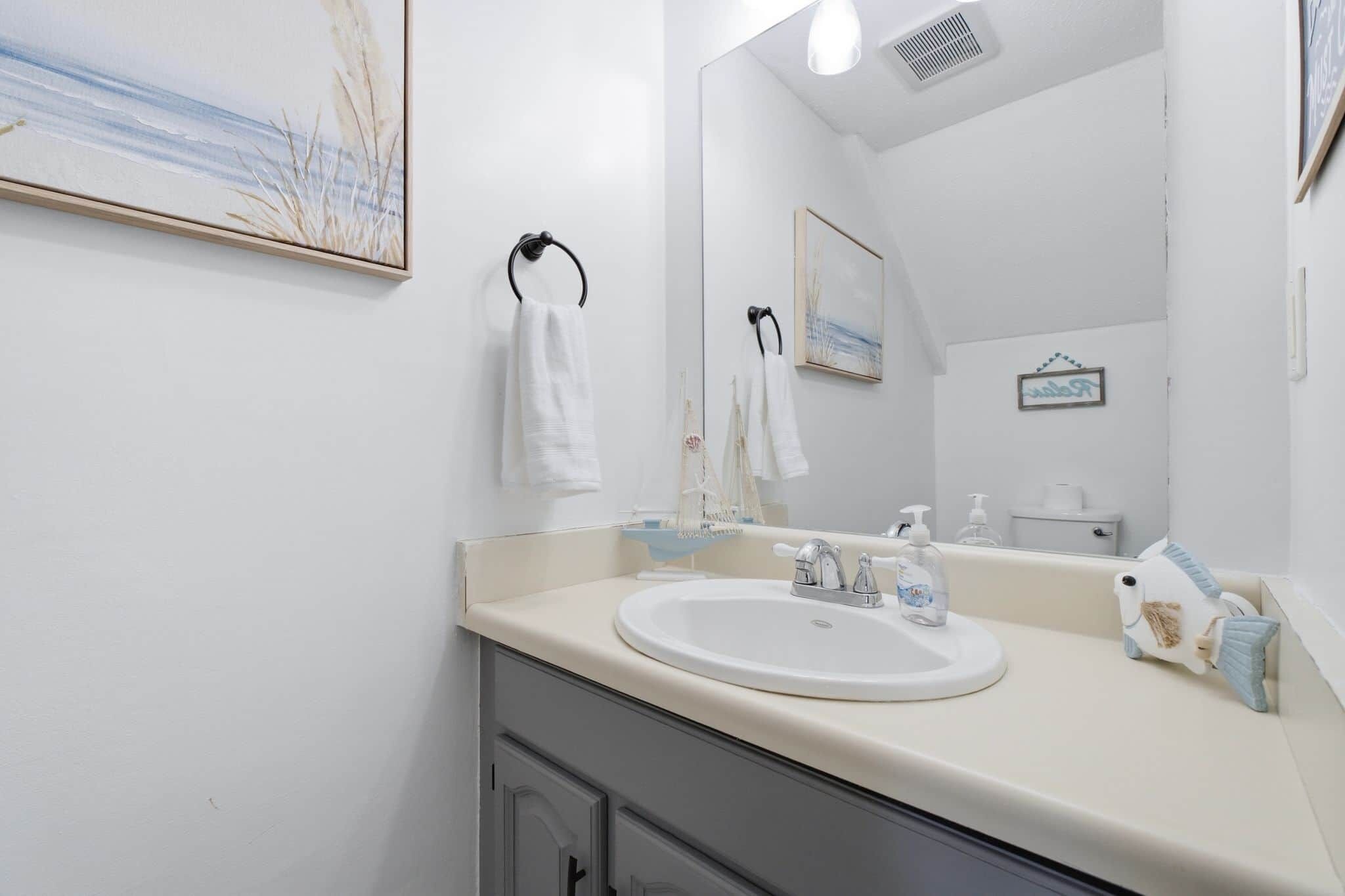 Ein Badezimmer mit Waschbecken, Spiegel und Handtuchhalter.