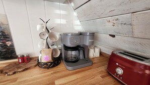 A kitchen with a coffee maker, a toaster, and a coffee grinder.