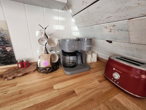A kitchen with a coffee maker, a toaster, and a coffee grinder.