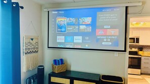 Ein Heimkino-System mit einem Bildschirm, der verschiedene Streaming-Dienste und ein Sportevent anzeigt.