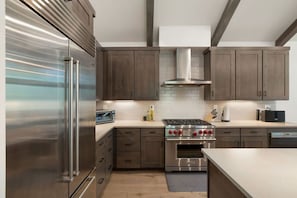 A modern kitchen with stainless steel appliances, wooden cabinets, and a tiled backsplash. - Sierra Luxe Retreat - Hot tub close to Stateline (Zephyr Cove)