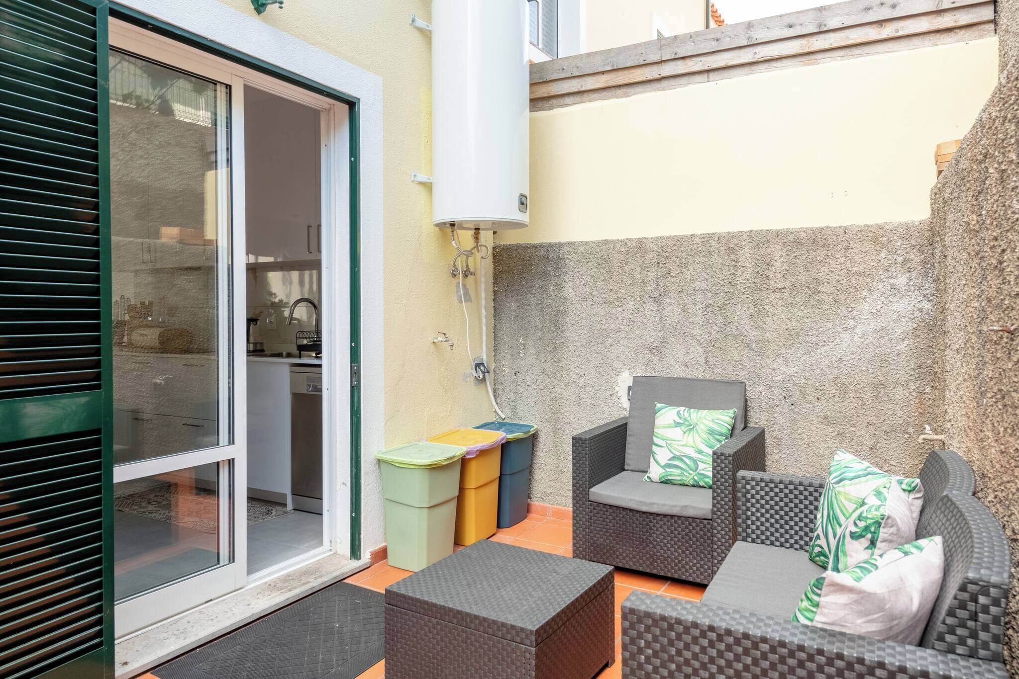A patio area with outdoor furniture, a sliding glass door leading to a kitchen, and a water heater mounted on the wall.