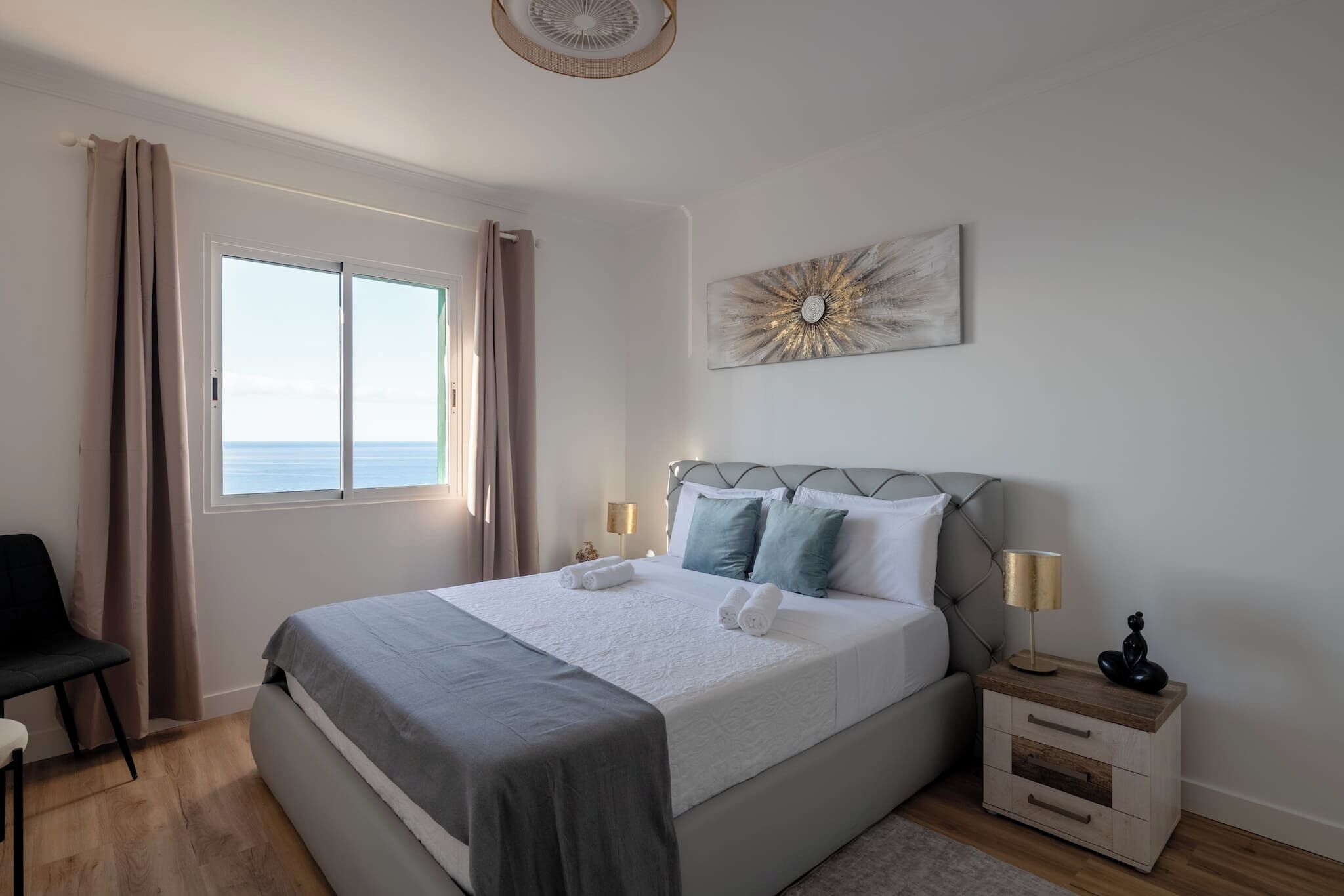 Une chambre à coucher avec un lit, une chaise, une table de chevet et une fenêtre.