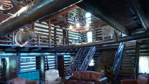 A rustic interior with wooden beams, leather furniture, and antlers mounted on the ceiling. - Amazing 6+-bedroom lodge in Spring Mills perfect for group getaways. (Spring Mills)