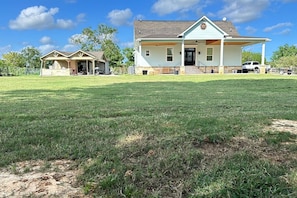 Uma casa de dois andares com um amplo jardim frontal e uma garagem.