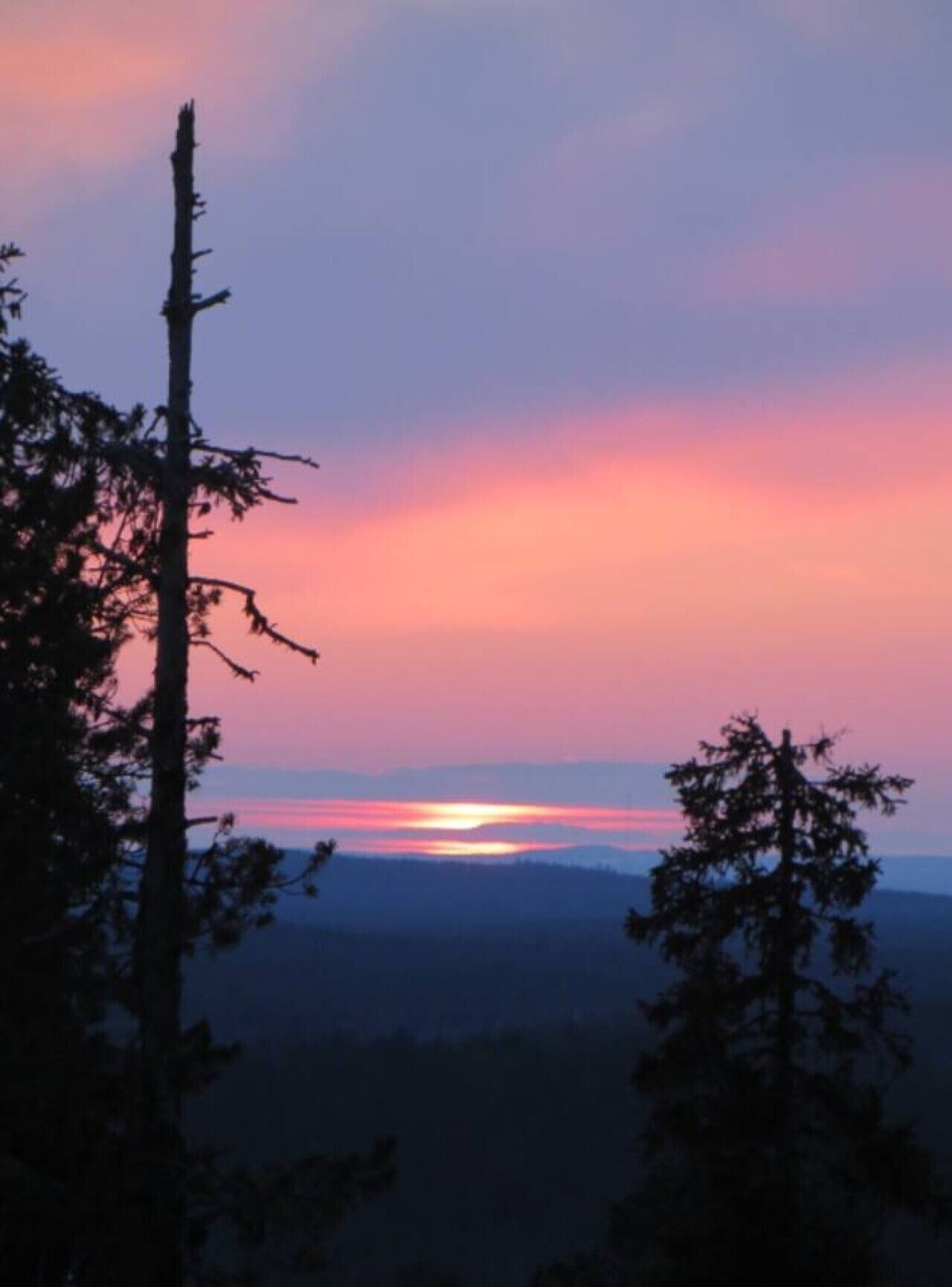 A sunset with a mountain range in the background.