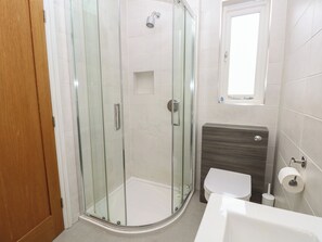 Ein modernes Badezimmer mit einer Duschkabine, einer Toilette und einem Waschbecken.