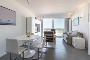 Een moderne hotelkamer met balkon, een eethoek en een zithoek.