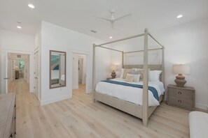 Ein Schlafzimmer mit einem Himmelbett, Nachttischlampen und einem großen Spiegel.