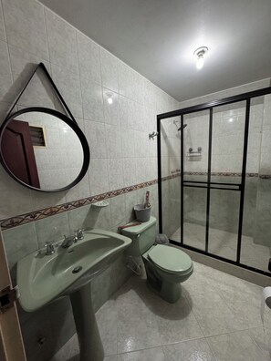 Ein Badezimmer mit Waschbecken, Toilette und Duschbereich.