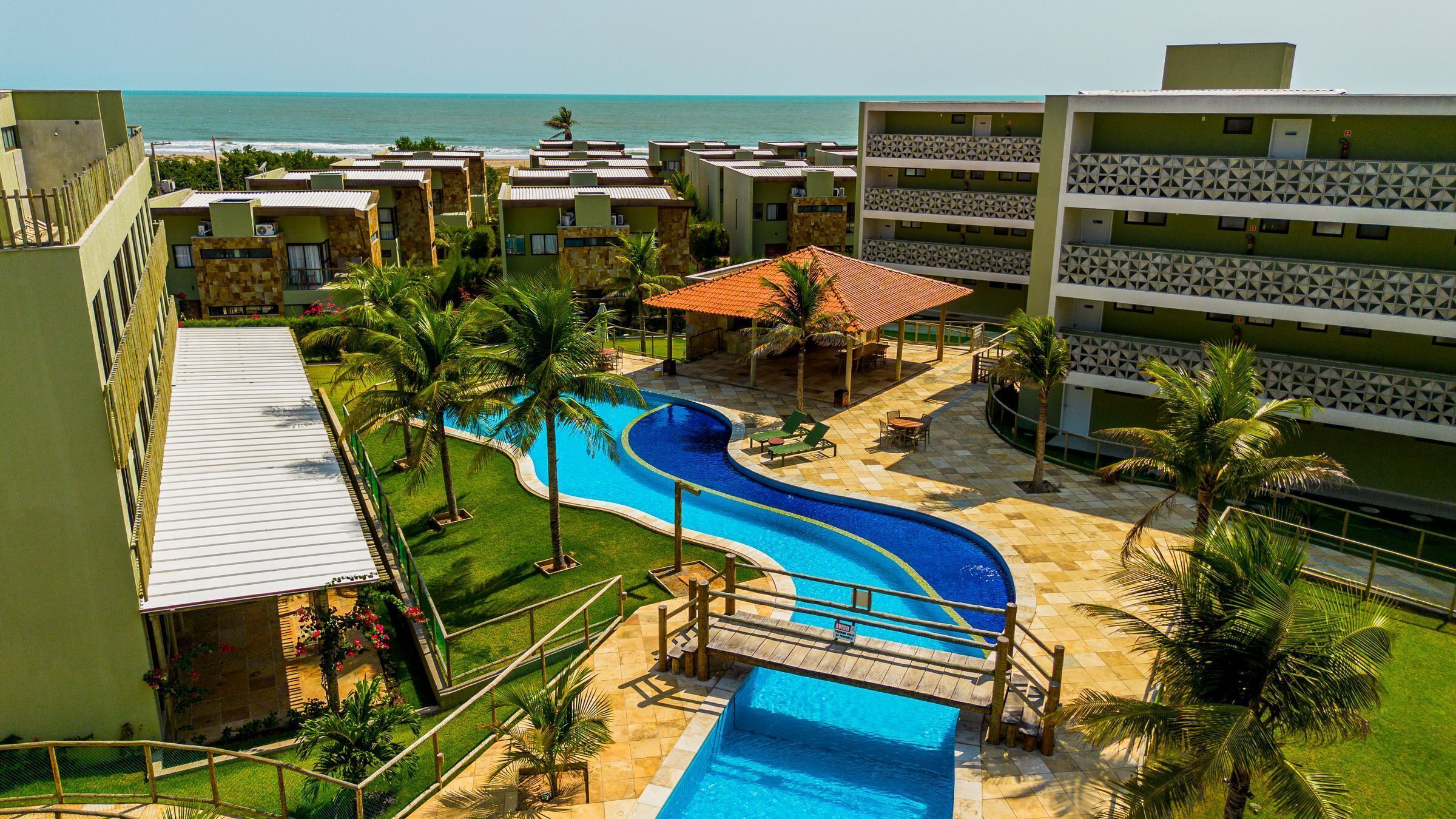 Un resort con piscina, palmeras y vistas al océano.