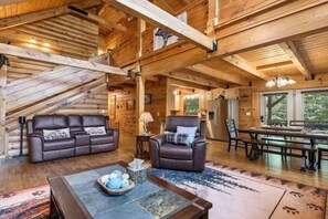 A log cabin interior with a living room, dining area, and kitchen. - Breezy Creek Retreat-Spectacular Waterfront Cabin! (Maggie Valley)