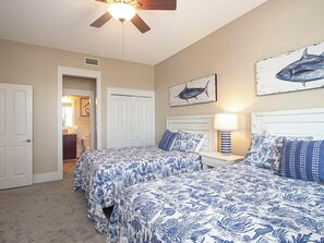 A bedroom with two beds, a ceiling fan, and artwork on the walls. - Kiva Village 204: Golf Course Views, Beach Club & Poolside Service (Gulf Shores)