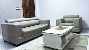 Una sala de estar con sofá, sillón y mesa de centro.