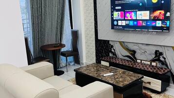 Una sala de estar moderna con un sofá, una mesa de centro y un televisor montado en la pared.