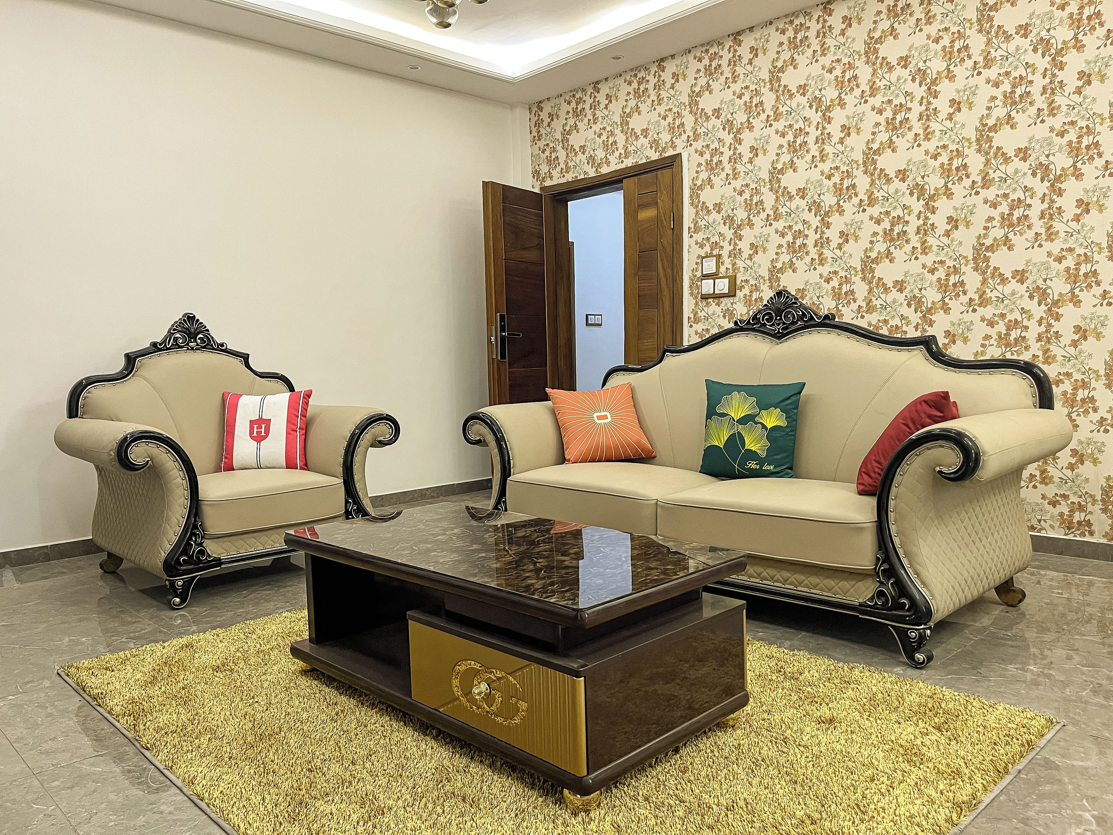 A living room with two sofas, a coffee table, and a patterned wall.