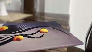 Primer plano de una mesa de diseño moderno, con tapa de vidrio y mantel oscuro.