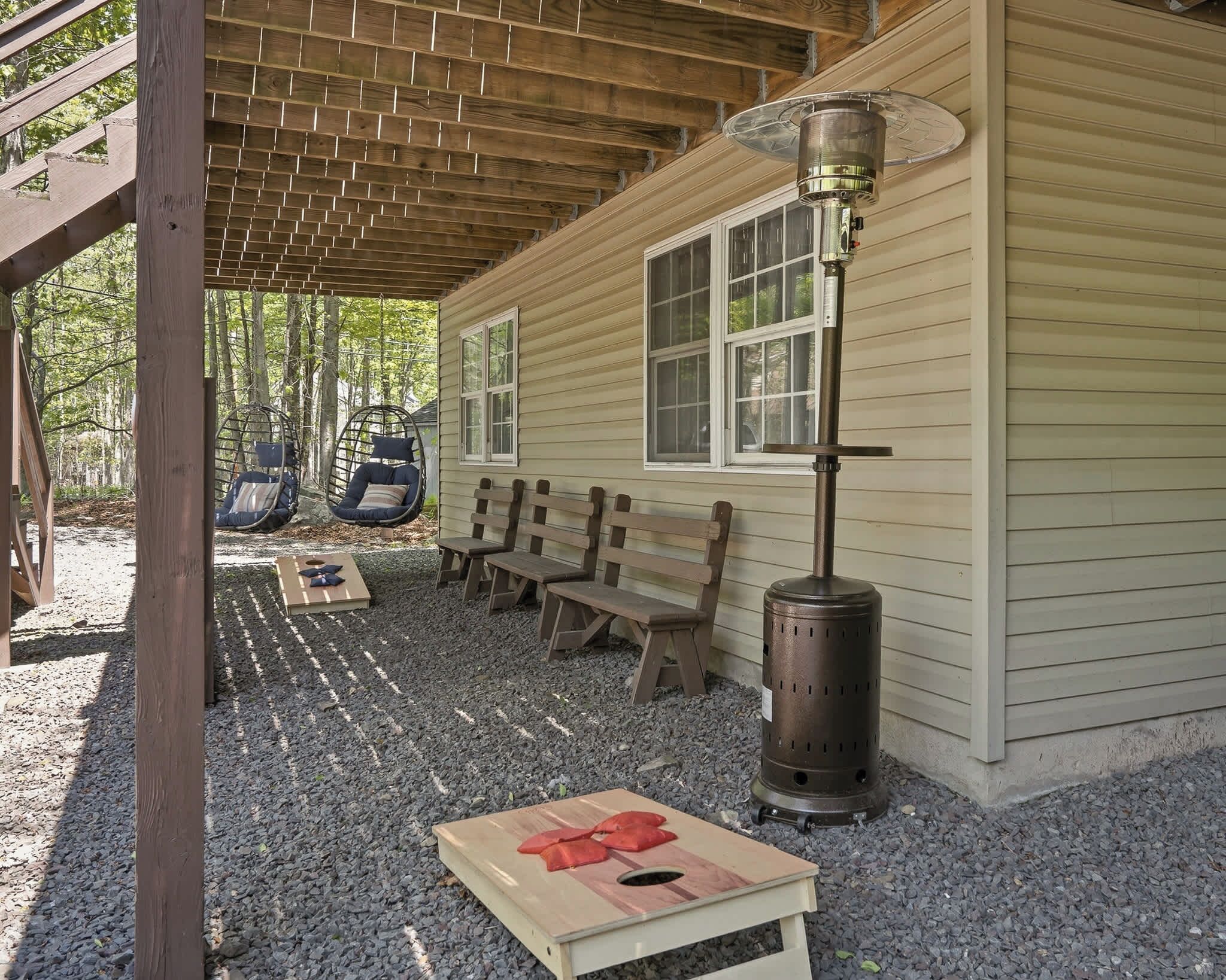 A covered outdoor seating area with benches and a wood-burning stove.
