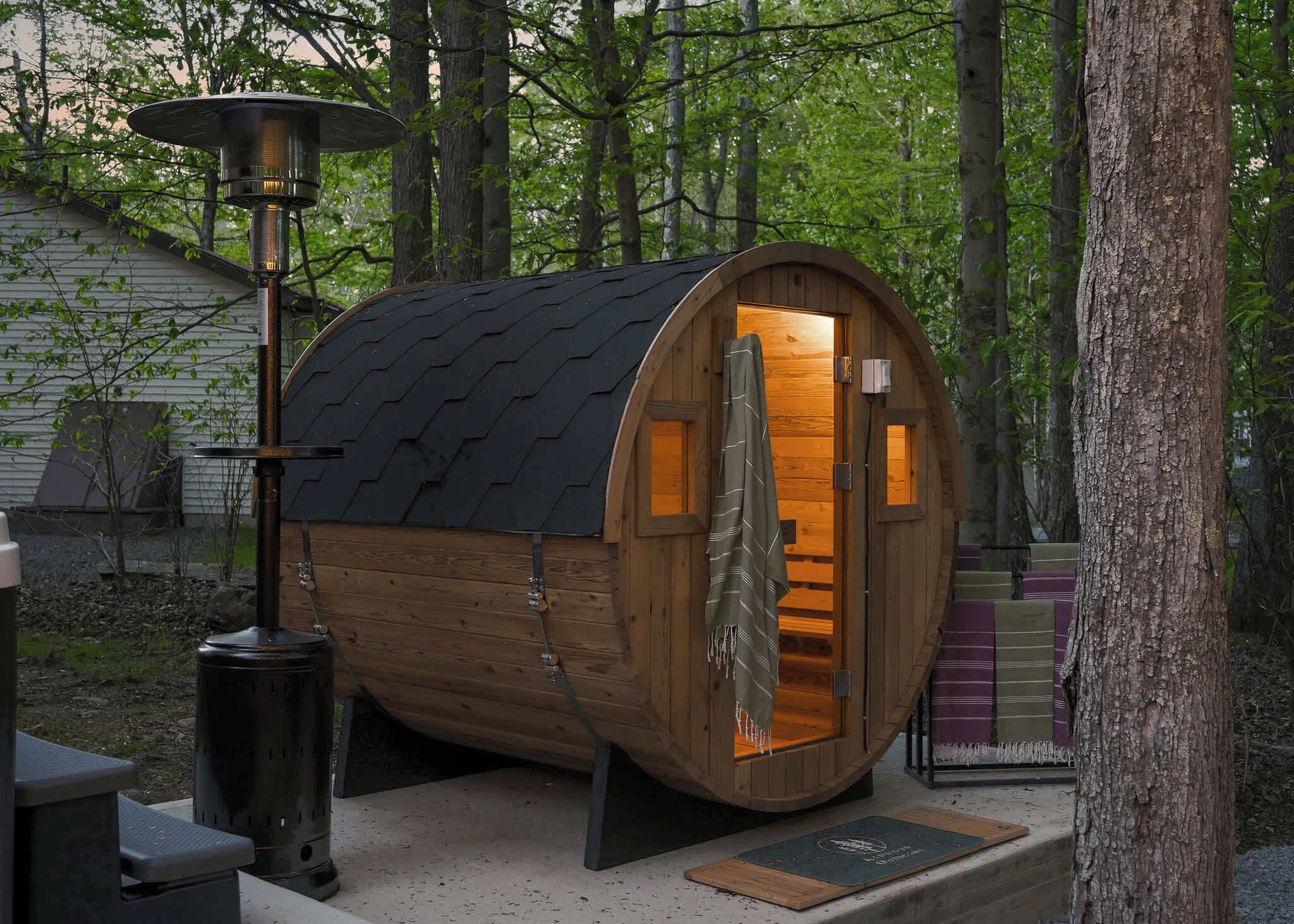 A wooden cabin with a curved roof, a chimney, and a door.