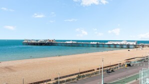 A beach with a pier extending into the sea, a clear sky, and a calm sea. - Seaview Haven | By My Getaways (Brighton)