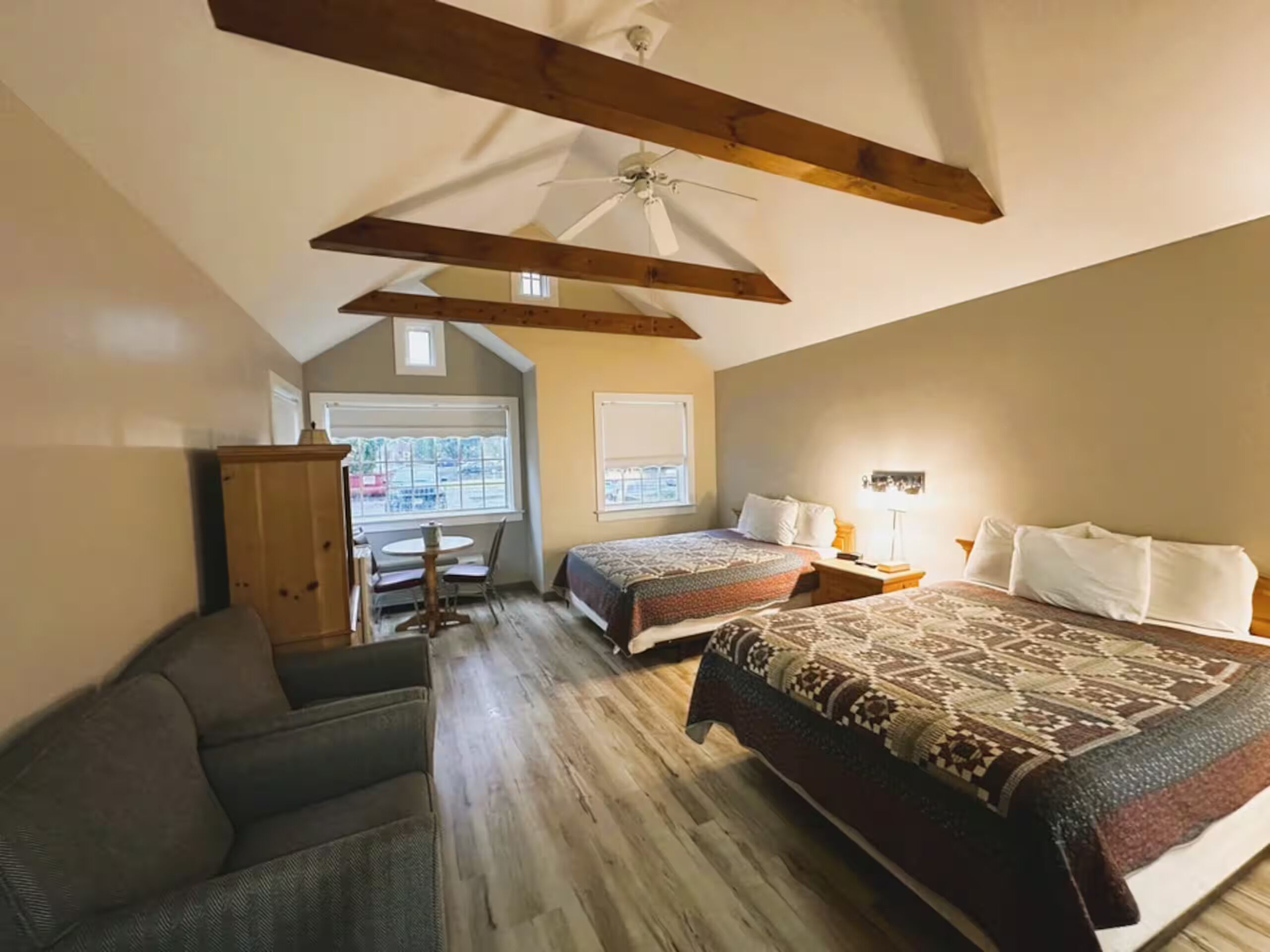 A bedroom with a large bed, two bedside tables, a ceiling fan, and a window.