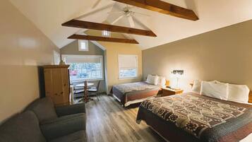 A bedroom with a large bed, two bedside tables, a ceiling fan, and a window.
