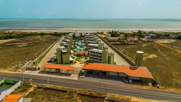 Um resort com piscina, vários edifícios e vista para o oceano.