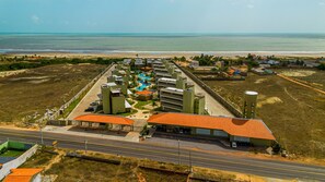Um resort com piscina, vários edifícios e vista para o oceano.