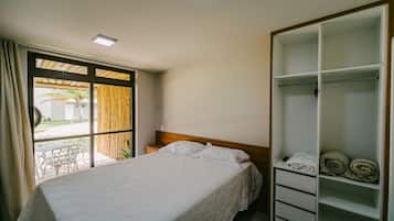 Quarto com cama, guarda-roupa e vista para o exterior.