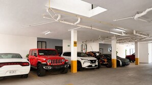 Ett parkeringshus med flera våningar d är olika typer av fordon står parkerade, bland annat stadsjeepar och en motorcykel.