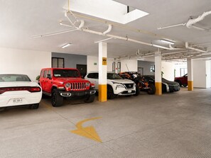 A multi-level parking garage with various vehicles parked, including SUVs and a motorcycle. - En el corazón de marina Mazatlán (Mazatlán)