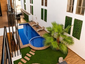 A rooftop pool area with a small circular pool, a palm tree, and a staircase leading to an upper level. - En el corazón de marina Mazatlán (Mazatlán)