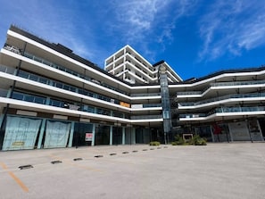 En bygning med flere etager og moderne arkitektur, med en central trappe og flere balkoner.