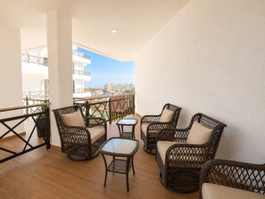 A balcony with wicker furniture and a view of the city. - Ubicación ideal | depto. nuevo con 2 recámaras (Mazatlán)