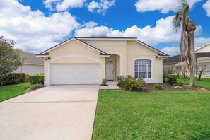 A single-story house with a garage, a front door, and a small porch. - 4-Bedroom Pool Home Near Disney | 2 Master Suites | Sleeps 10 (Clermont)