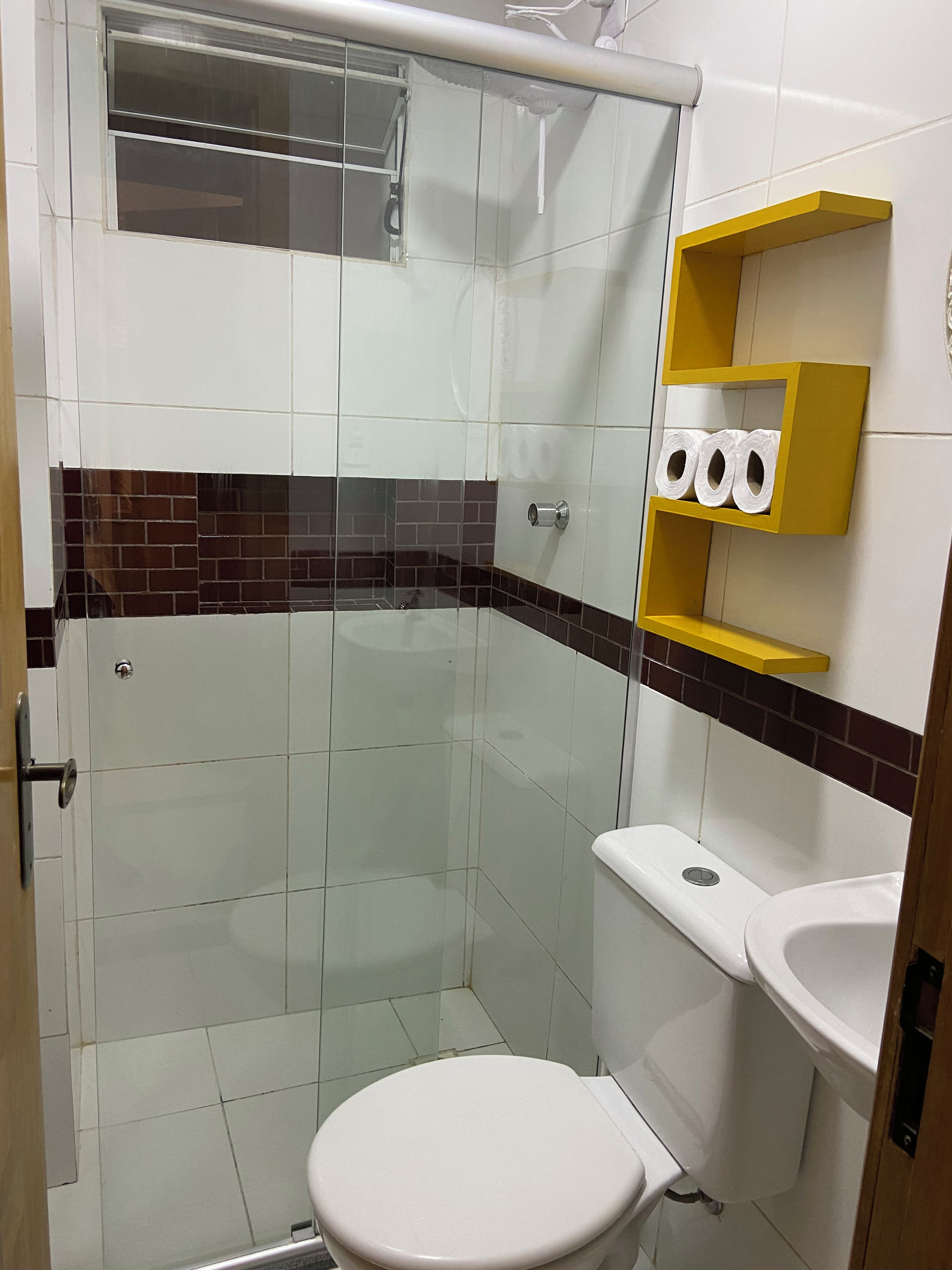 Ein Badezimmer mit einer Duschkabine, einer Toilette und einem Waschbecken.