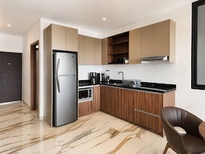 A modern kitchen with a built-in refrigerator, microwave, and stove. - Dpto. nuevo a unos pasos de malecón y zona dorada (Mazatlán)