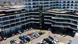 A multi-story hotel with a central atrium, a parking lot, and a view of the surrounding cityscape. - Dpto. nuevo a unos pasos de malecón y zona dorada (Mazatlán)