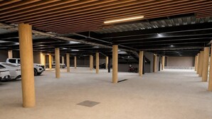 A spacious indoor parking area with multiple columns and rows of parked vehicles. - Dpto. nuevo a unos pasos de malecón y zona dorada (Mazatlán)