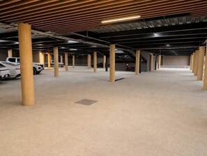 A spacious indoor parking area with multiple columns and rows of parked vehicles. - Dpto. nuevo a unos pasos de malecón y zona dorada (Mazatlán)