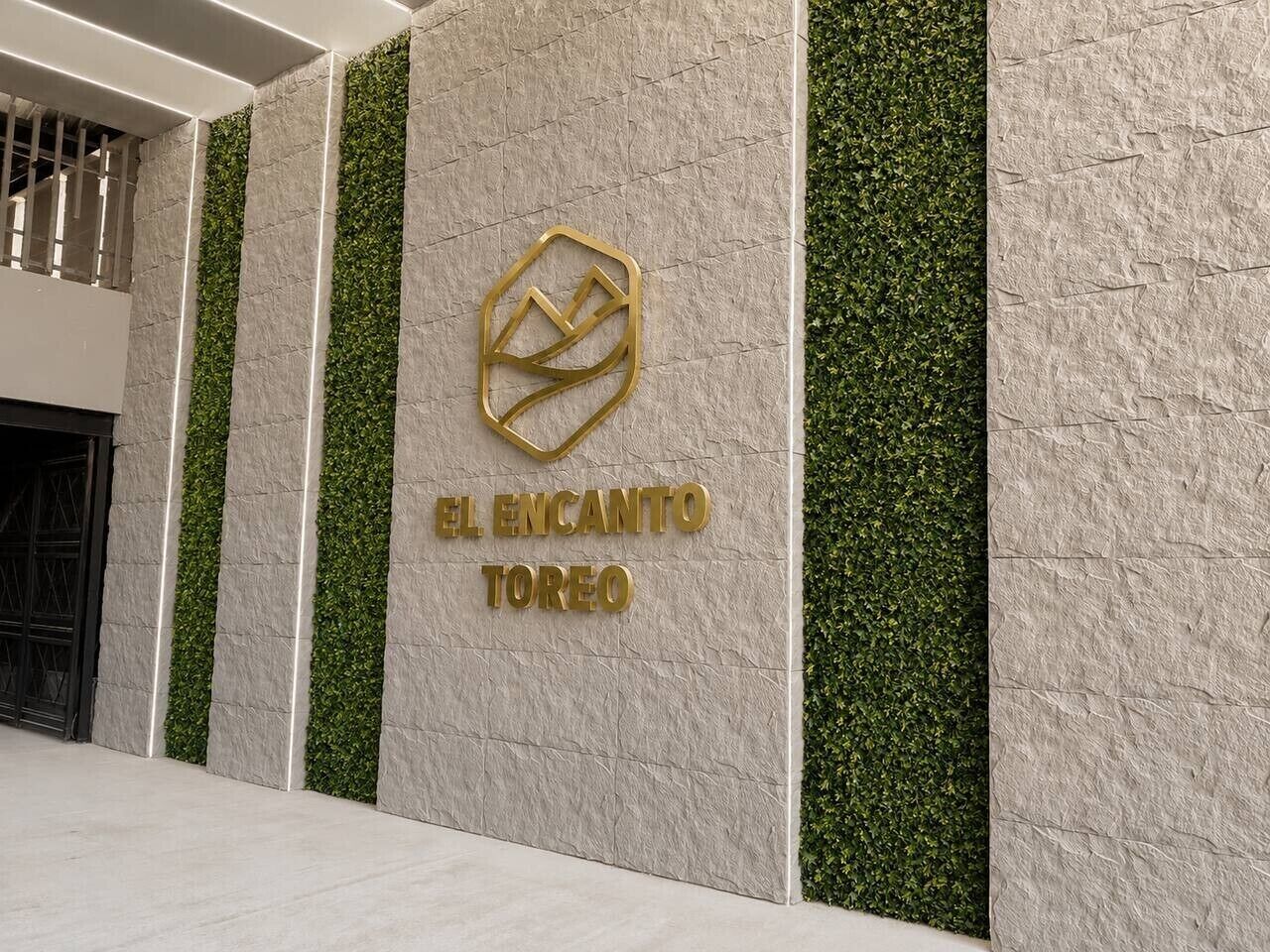 En vägg med en logotyp och texten ”EL ENCANTO TOREO”, vilket anger namnet på ett hotell.