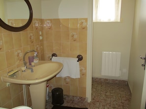 Ein Badezimmer mit Waschbecken, Spiegel und Handtuchhalter.