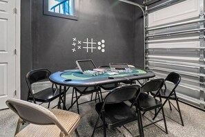 Ein Konferenzraum mit rundem Tisch, vier Stühlen, einem Laptop und einem Pokertisch.