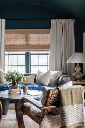A cozy living room with a sofa, a coffee table, and a lamp. - Hotel Bebe Main House - Sleeps 6 (Round Top)